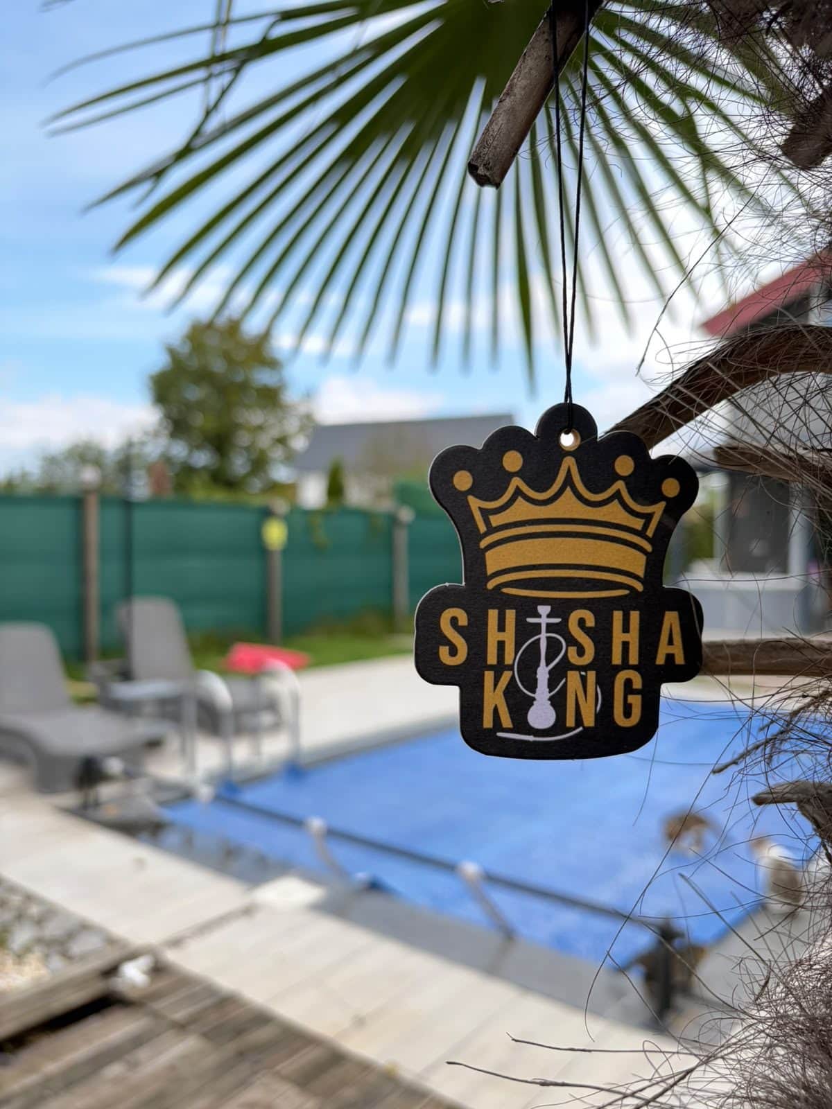 Black crown-shaped car air freshener with a gold logo for a shisha bar